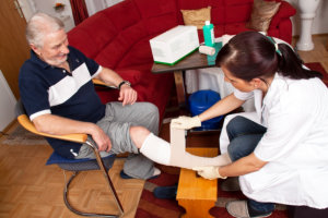 nurse applying bandage to patient's foot