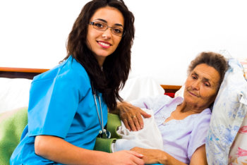 nurse taking care of her patient in bed